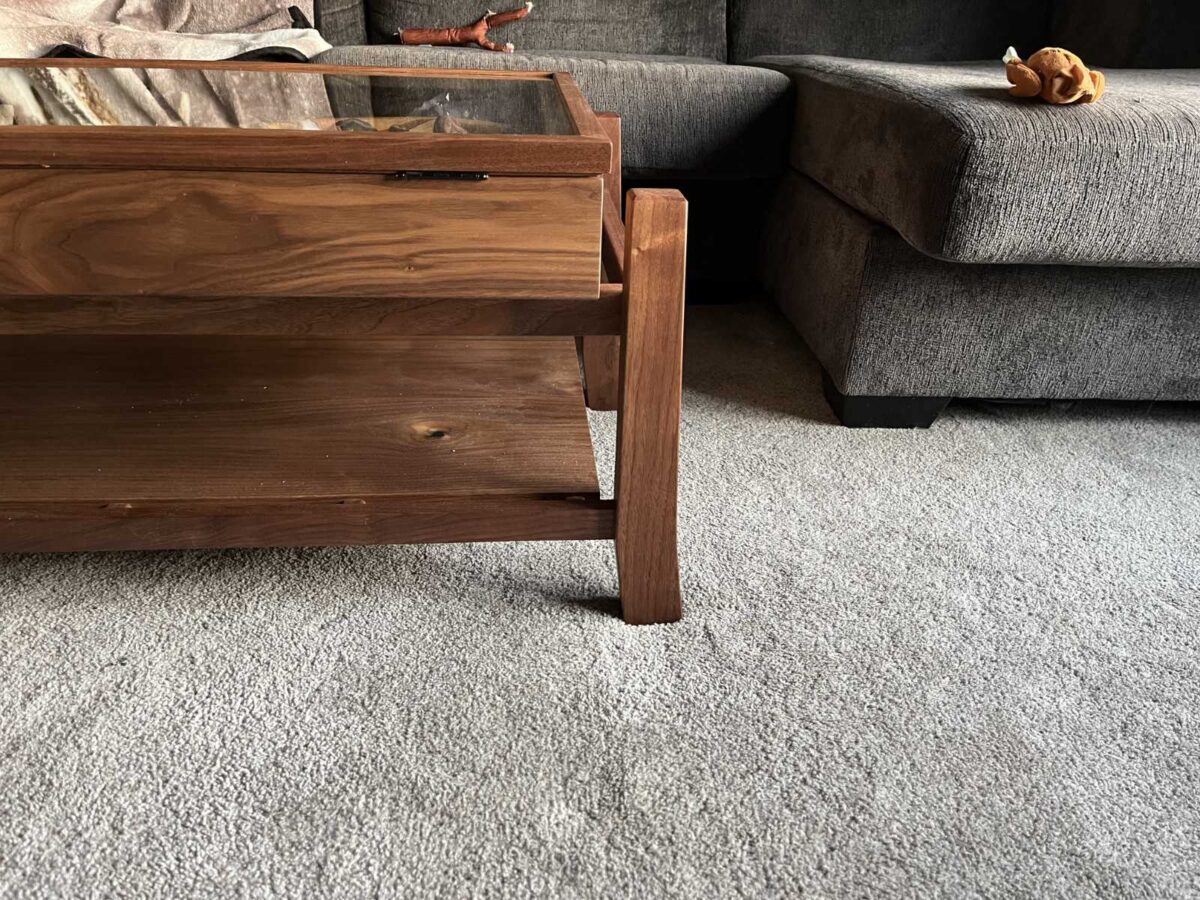 detail view of custom table leg and shelf design for walnut display coffee table with glass hinged lid to display client's collection of agate stones