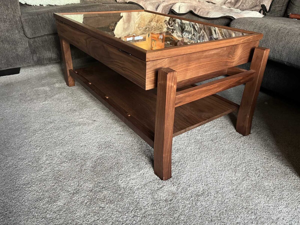 side view of walnut display coffee table with glass hinged lid to display client's collection of agate stones