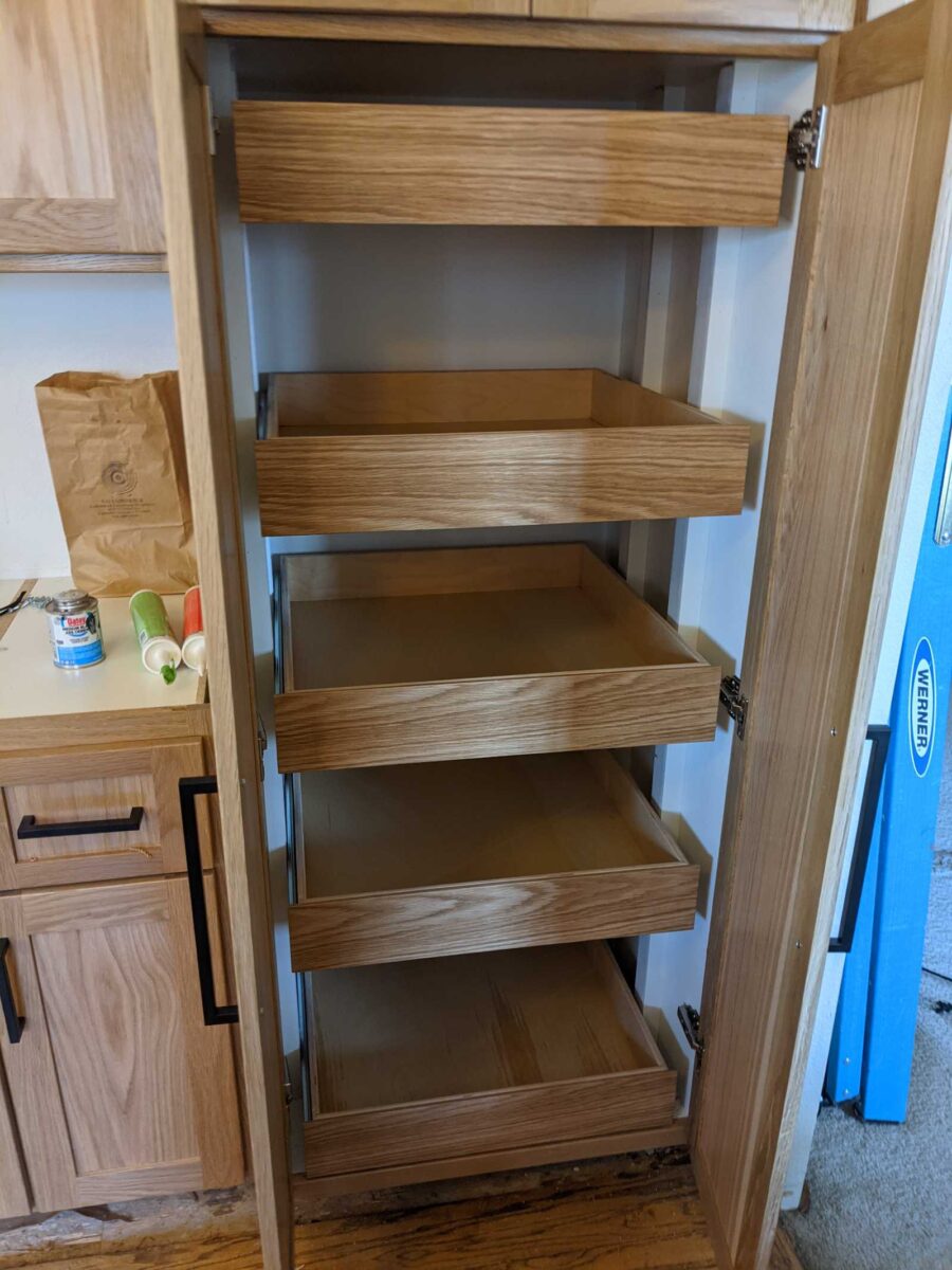 Built-in pantry of white oak with natural wash, silde out drawers for ease of retrieving pantry items.