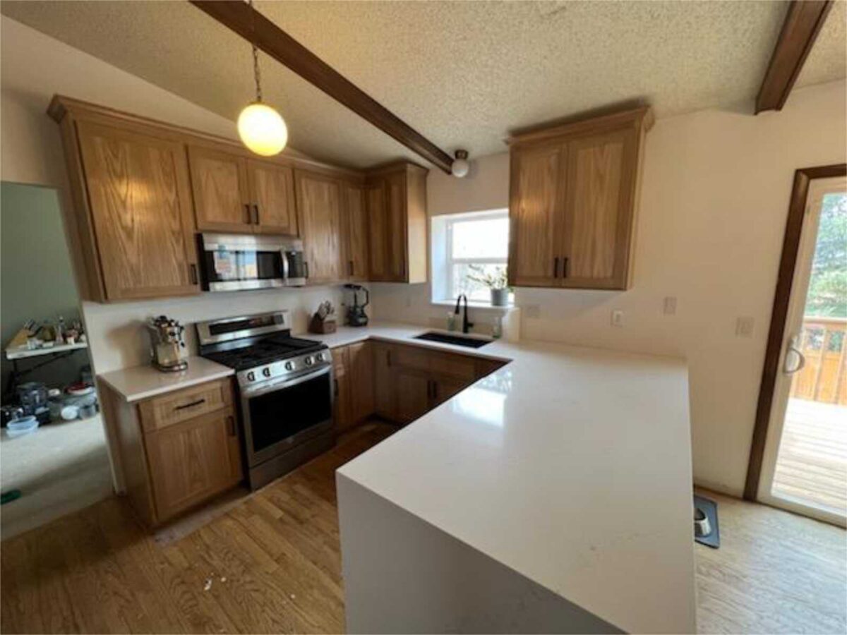 remodel of kitchen cabinetry to replace makeshift office on dividing wall, add a pantry and create a white wash look, without the "white". Easy care white countertop complements custom built white oak cabinetry with general finish to reveal the natural beauty of white oak wood