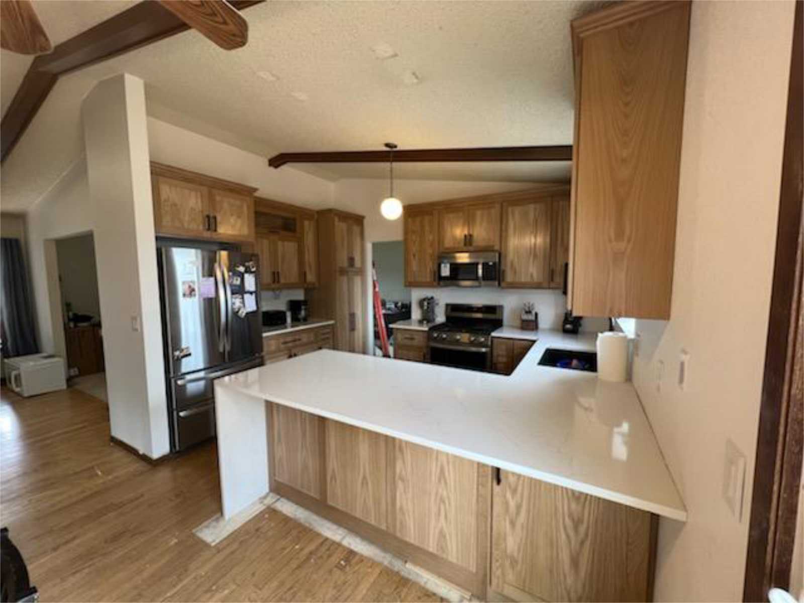 remodel of kitchen cabinetry to replace makeshift office on dividing wall, add a pantry and create a white wash look, without the "white". Easy care white countertop complements custom built white oak cabinetry with general finish to reveal the natural beauty of white oak wood