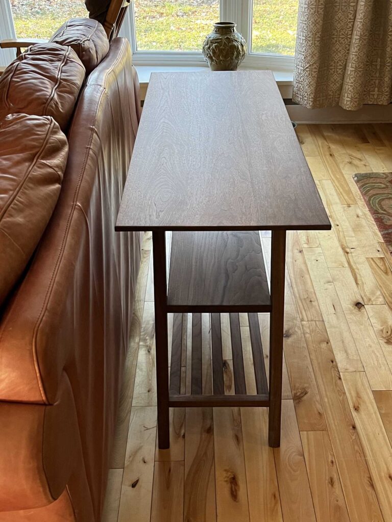 solid walnut sofa height table, with showing two shelves below table top